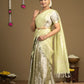 Woman wearing a light green saree with a brown background